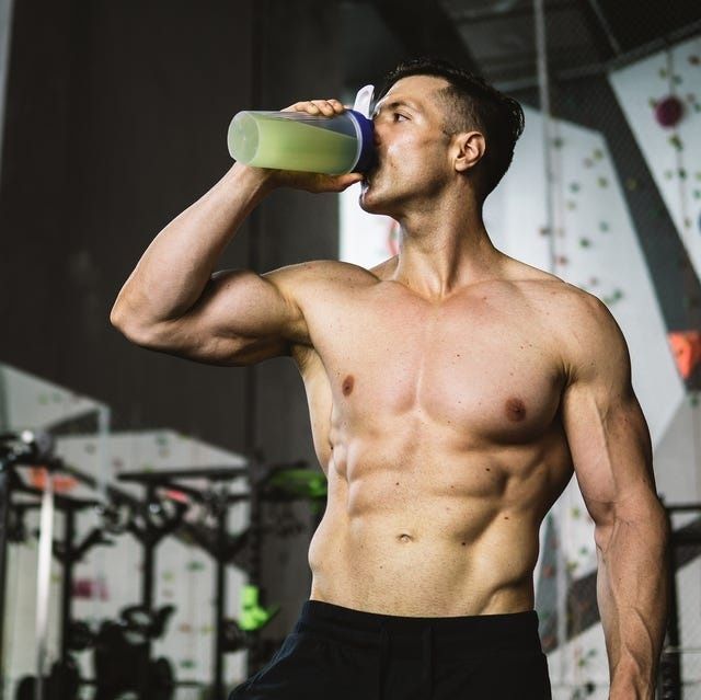 Atleet drinkt een groene eiwitshake in de sportschool na krachttraining